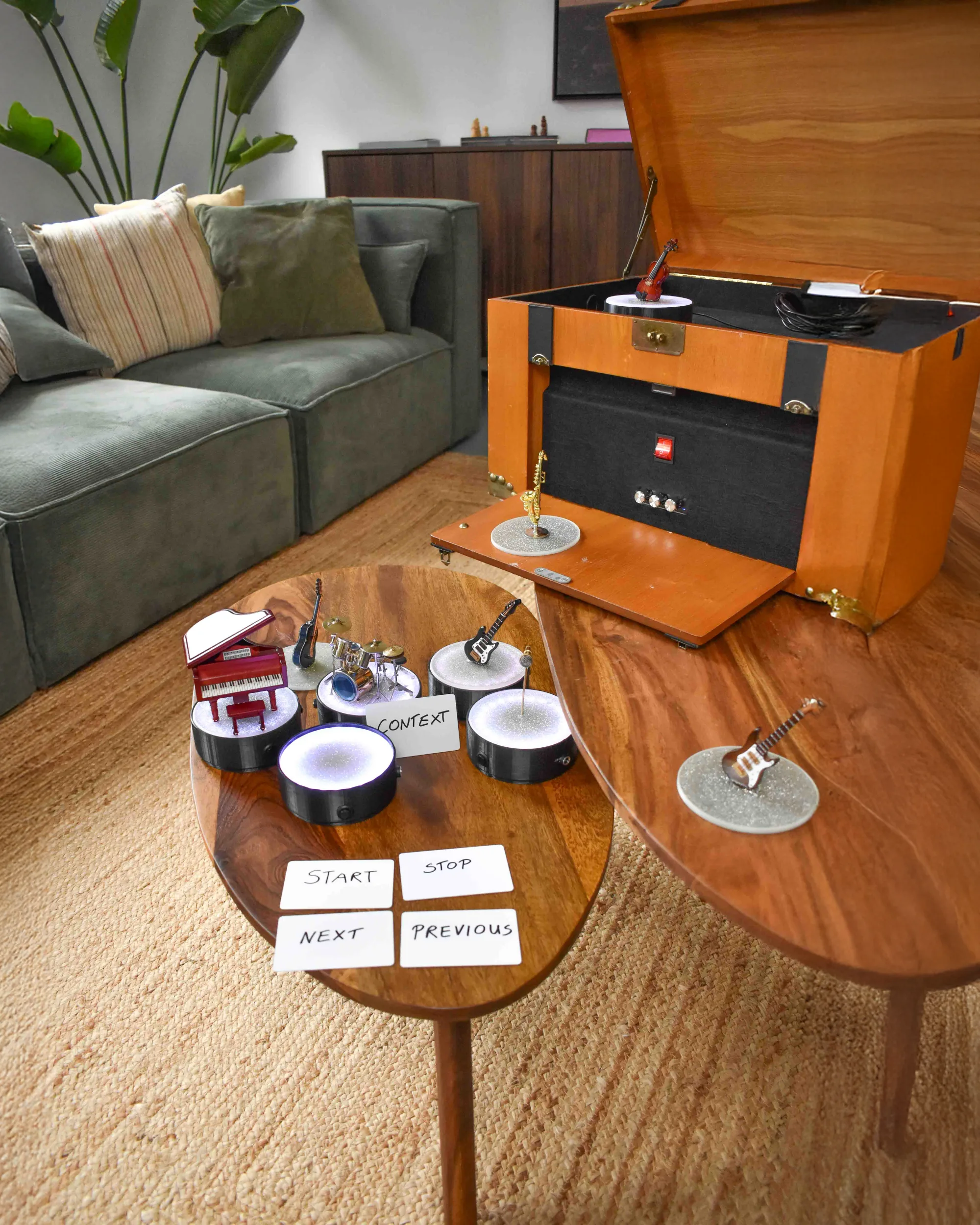A Limupu session set up in a living room, with instrument figures on glowing stations and control cards on the coffee table